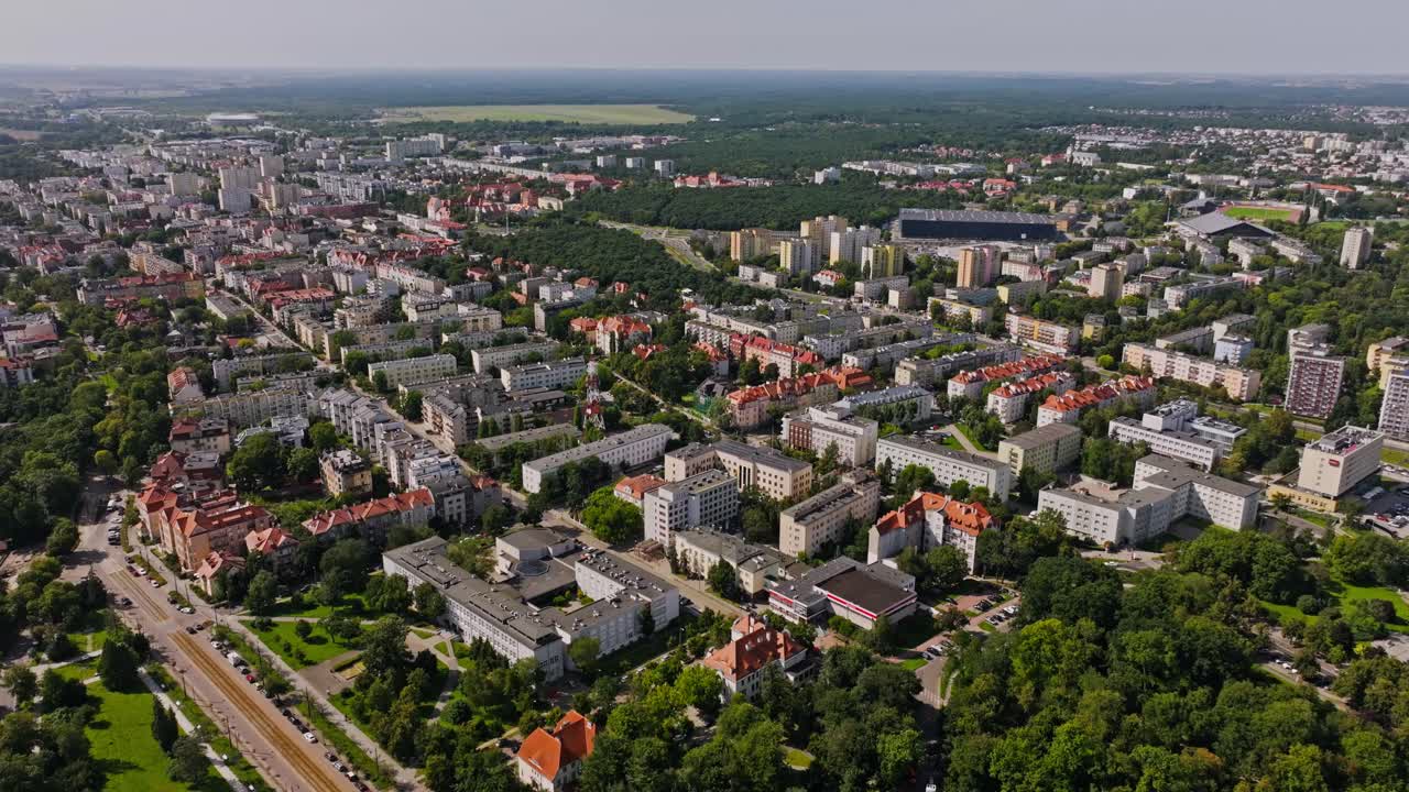 Jevn droneflygning fremover som viser arkitekturen i Torun og sommergrønt
