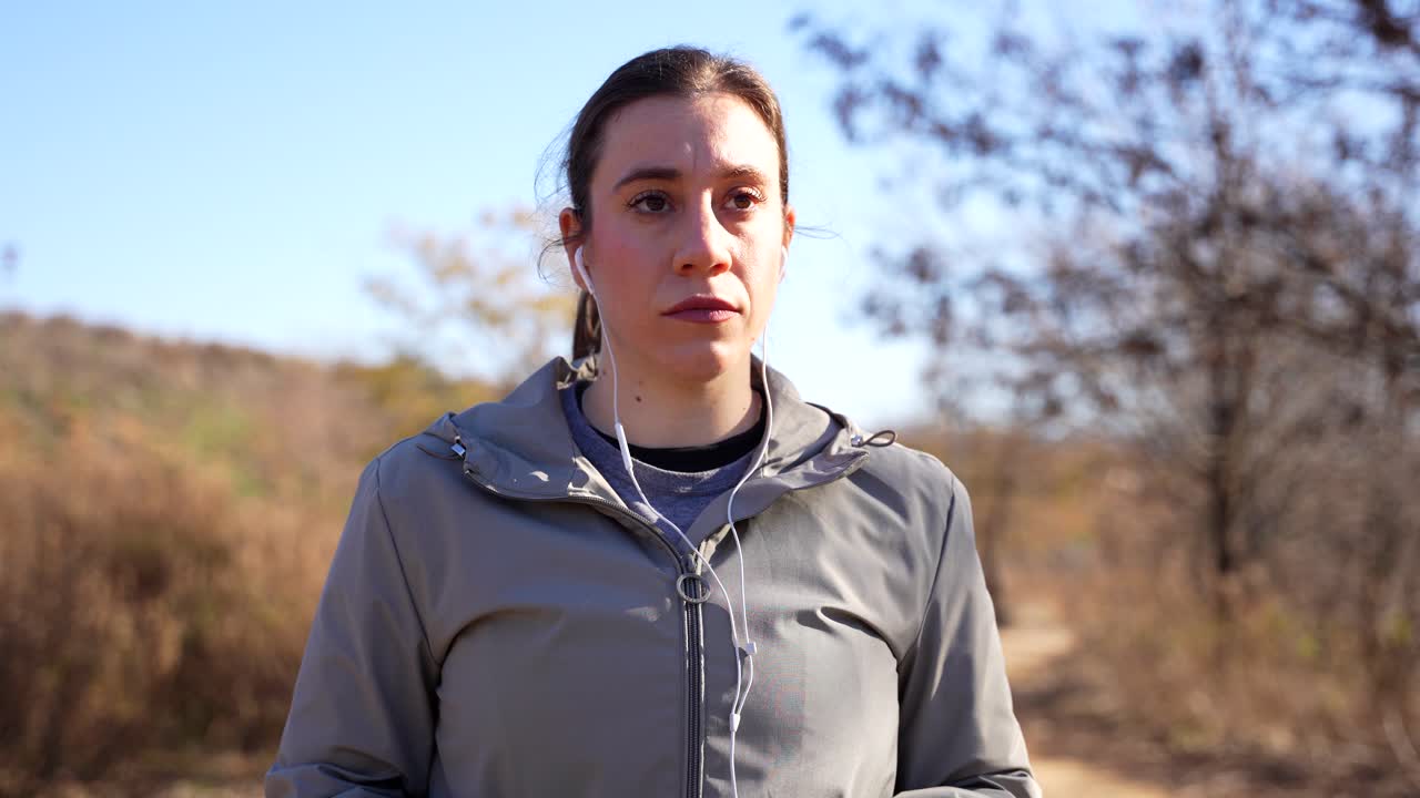 Woman putting on the earphones and concentrating to start running. Close up