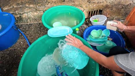 two people collaboratively washing dishes in a tub