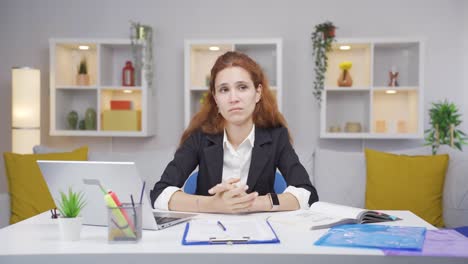 Mujer-Trabajadora-De-Oficina-En-Casa-Mirando-Emocionalmente-A-La-Cámara.