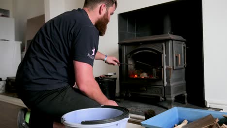 Bearded-Man-tends-to-his-indoor-fire