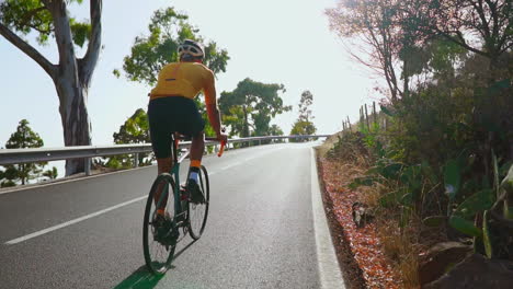 Un-Hombre-Monta-Su-Bicicleta-De-Carretera-En-Una-Carretera-Vacía-Por-La-Mañana,-Haciendo-Ejercicio-Al-Aire-Libre.-Las-Imágenes-En-Cámara-Lenta-Resumen-La-Emoción-De-Los-Deportes-Extremos.