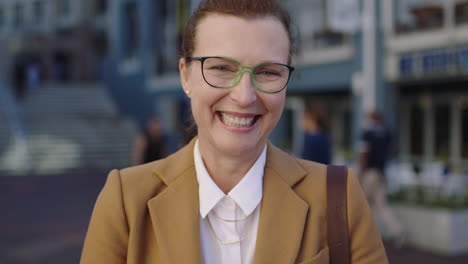 portrait of elegant mature business woman laughing cheerful in urban background wearing stylish suit jacket