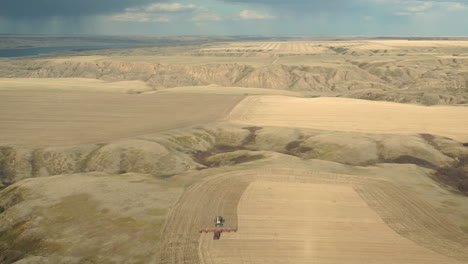 un tractor de siembra en el trabajo en el amplio terreno de tierras de cultivo en saskatchewan, canadá