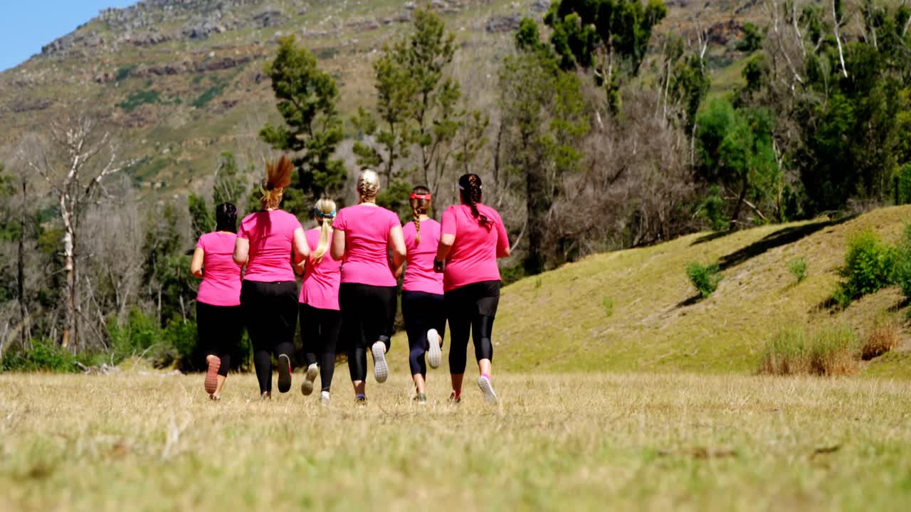 grupo de mujeres corriendo mientras entrenan en el campamento de entrenamiento