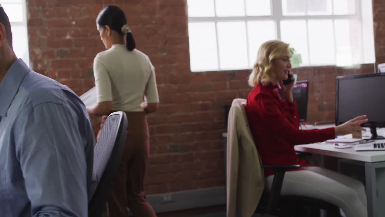 grupo diverso de colegas de negocios sentados en escritorios, leyendo documentos hablando en teléfonos inteligentes