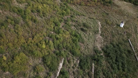 Luftaufnahme-Eines-Alten-Vernachlässigten-Weinbergs-Am-Hang-Mit-Einer-Kleinen-Kapelle