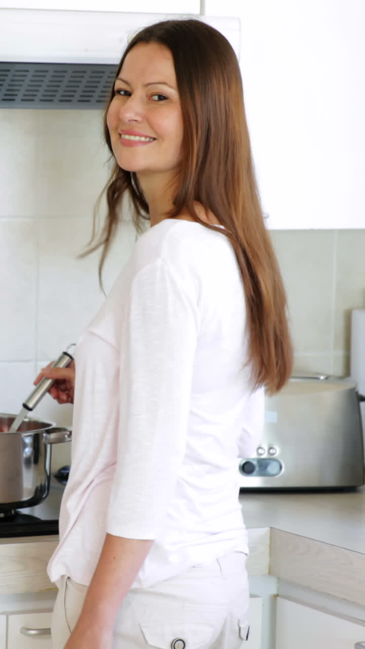 Bella donna che prepara la cena ai fornelli