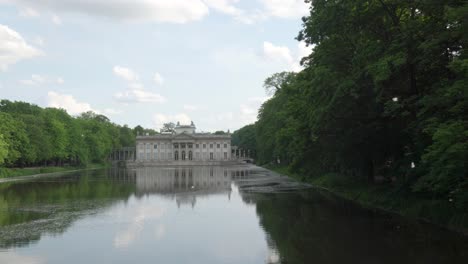 Lazienki-Palace-in-Warsaw-with-lake-and-park-and-particles-of-plants-flying-around-in-springtime