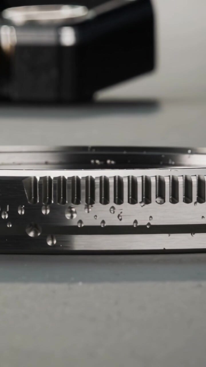 Vertical video: Camera panning bezel showing teeth, 2170 ID and droplets in studio, blurred watch