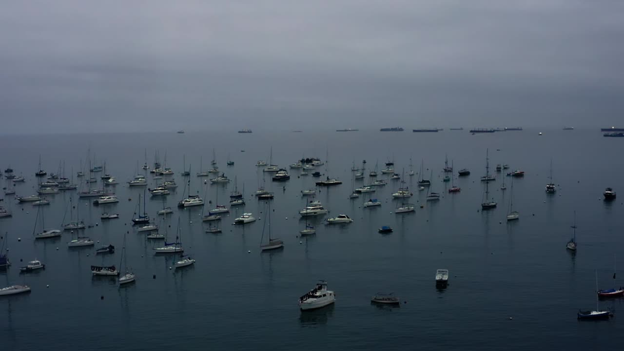 A calm scene of anchored boats on a still Pacific Ocean at La Punta Callao, Peru