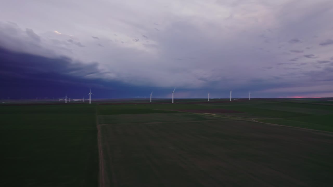 저녁에 극적인 폭풍우 하늘 아래 광활한 녹색 에 풍력 터빈
