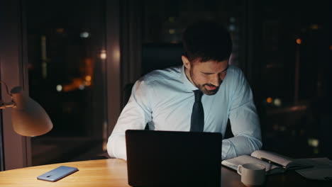 distressed businessman looking computer worried problem at night office close up