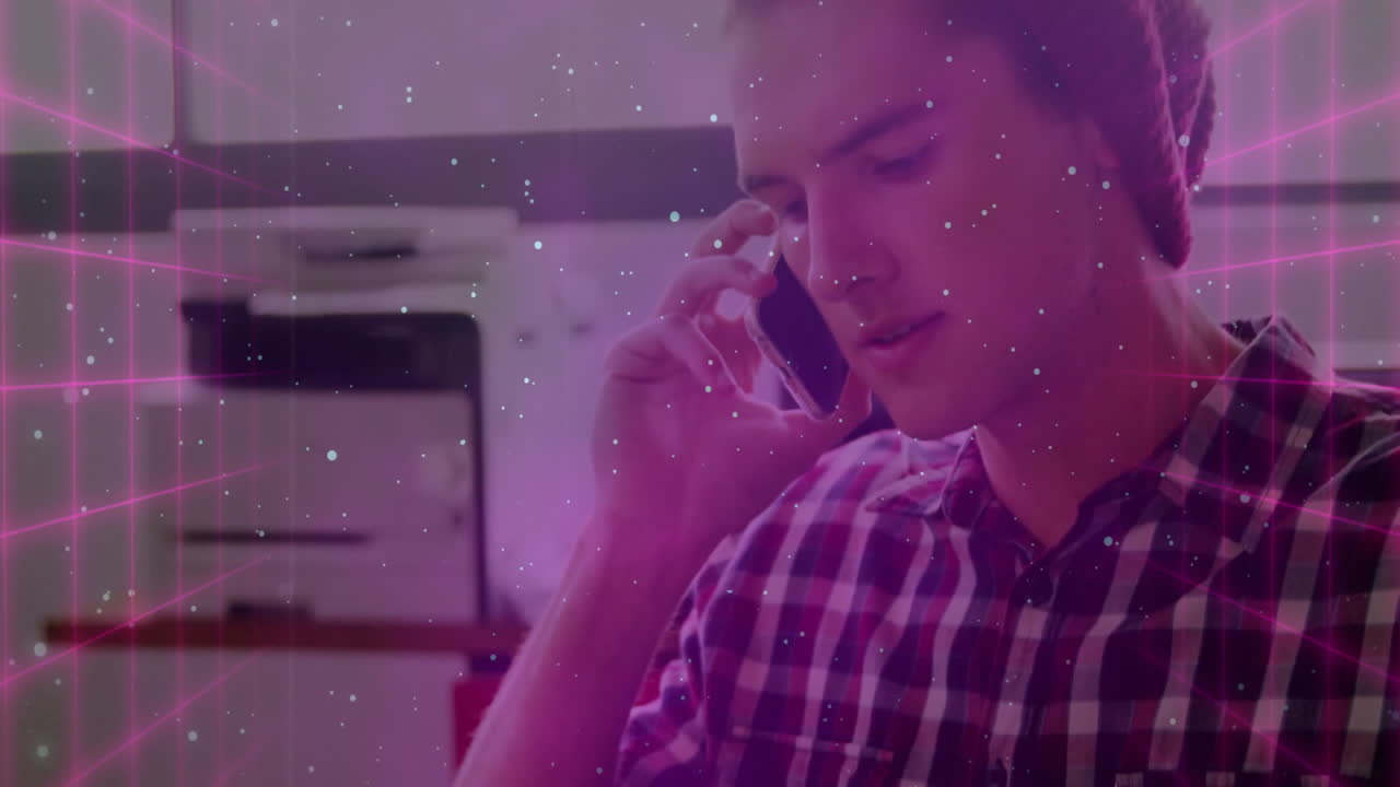 man talking on smartphone by printer in tech office, displaying magenta grid and white speckles