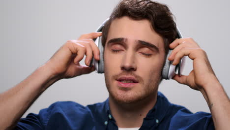 handsome man listening music in headphones. guy enjoying music in earphones