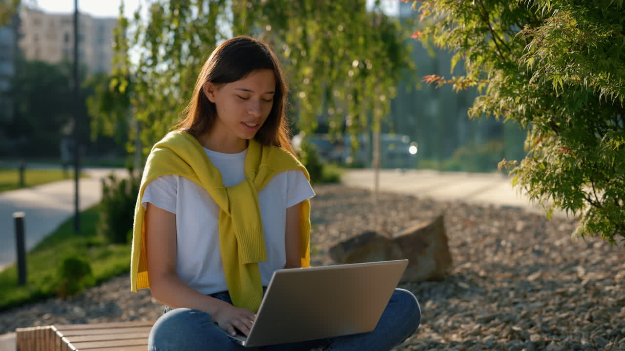 공원 에서 노트북 을 사용 하고 있는 여자