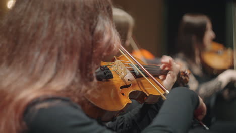 violins in symphonic orchestra female musicians are playing music string instrument