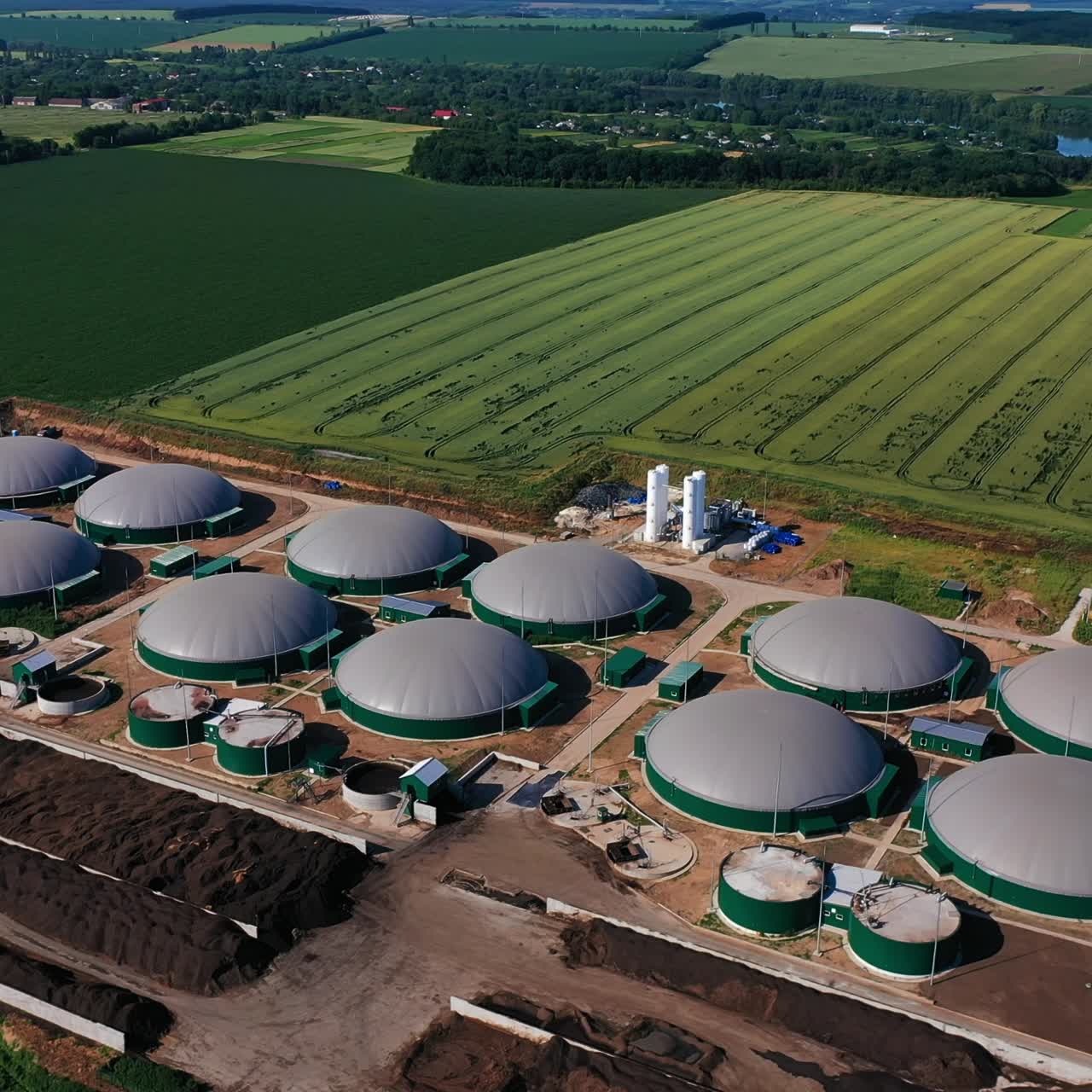 Innovative biogas plant on green plantations. New energy production of safe energy from biomass. View from top