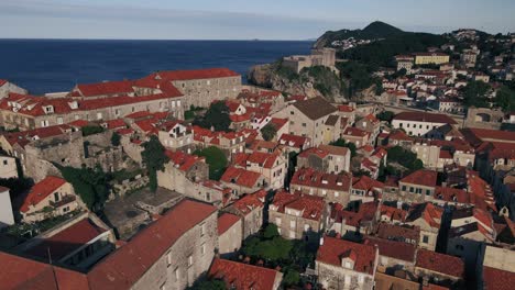 Drones-Aéreos-Volando-Lentamente-Sobre-Los-Tejados-De-Terracota-Roja-Del-Casco-Antiguo-De-Dubrovnik,-Croacia,-Terminando-En-Fort-Lovrijenac