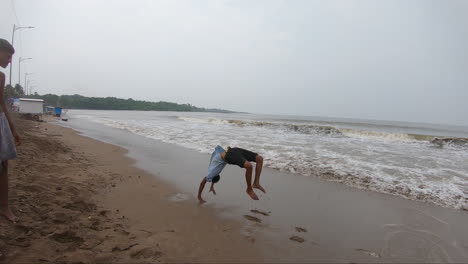 a-teenage-boy-somersaults-on-the-beach