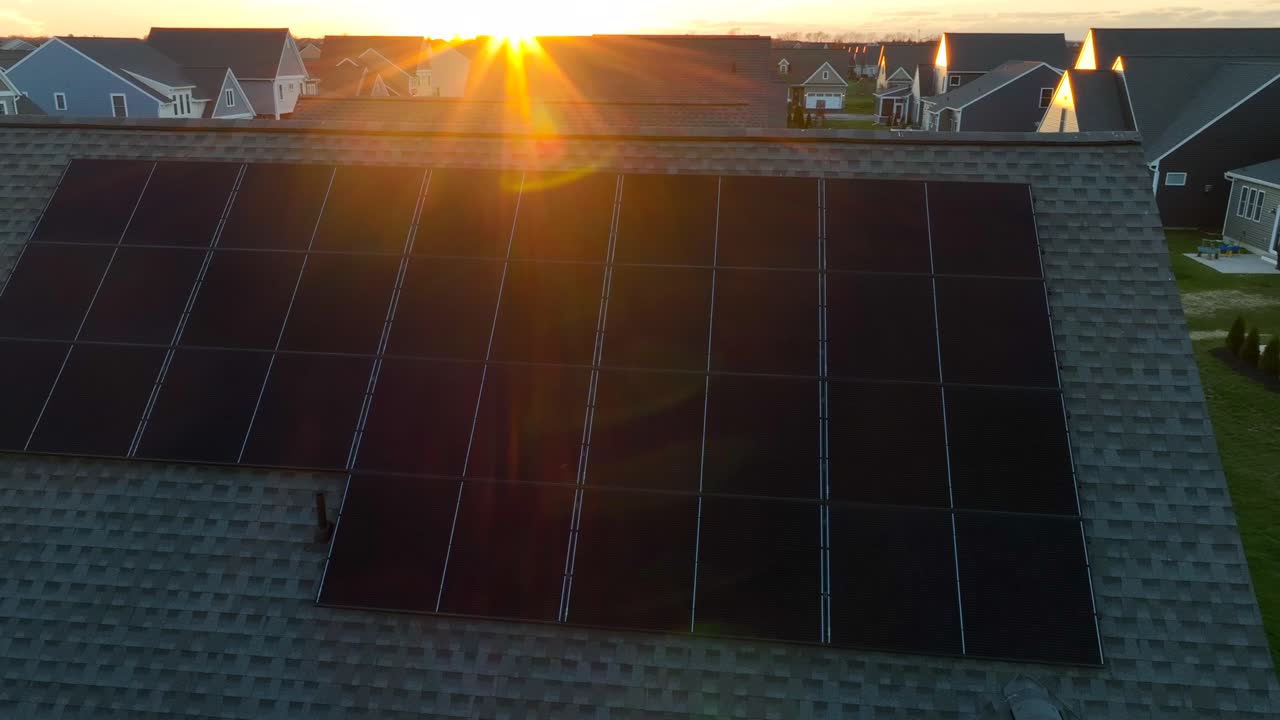 paneles solares en el techo de pizarra inclinado durante la puesta de sol de la hora dorada