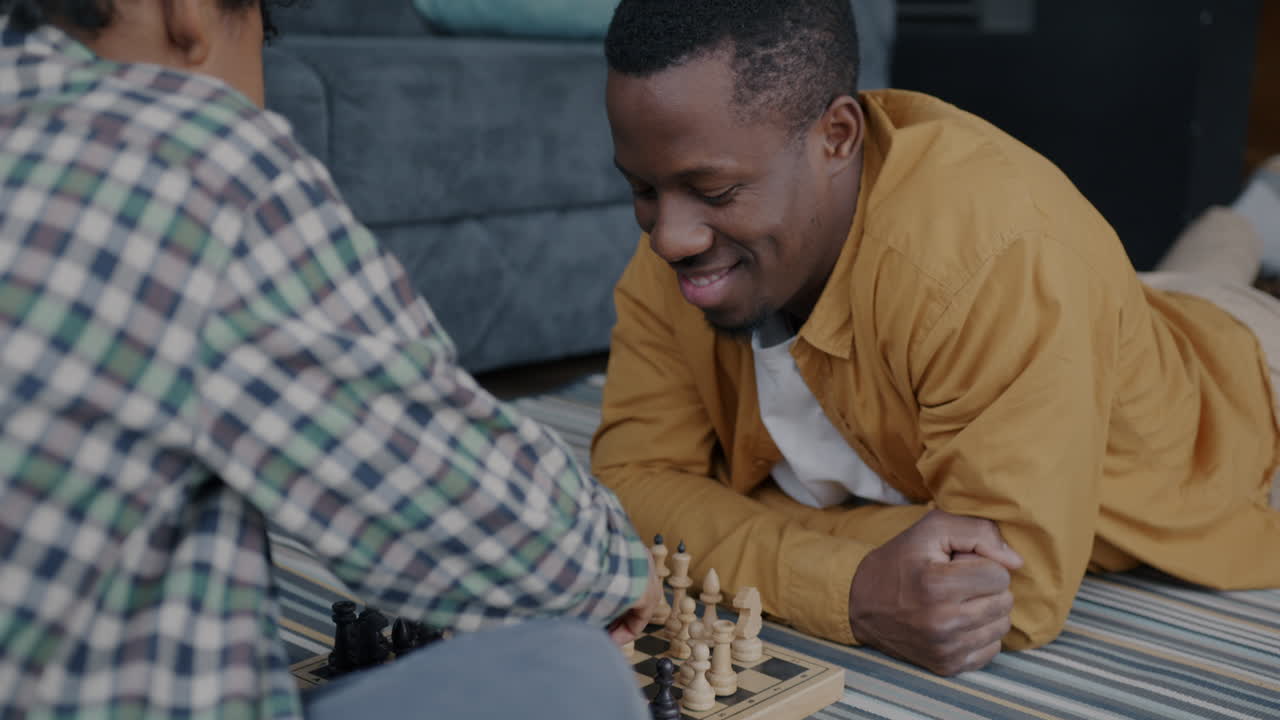 padre e hijo jugando al ajedrez en casa