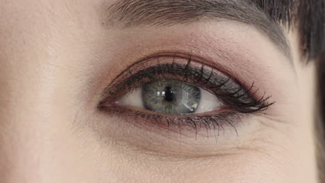 close up woman eye wearing makeup looking happy at camera blinking beauty cosmetics