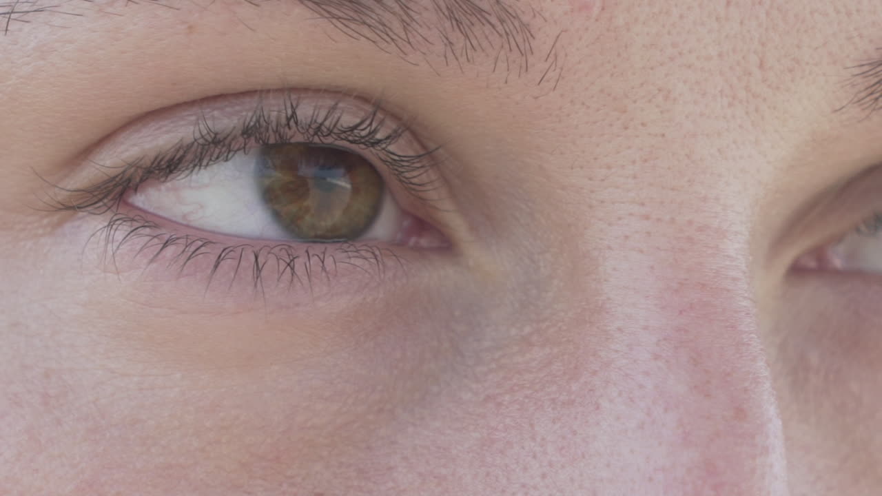 Brown eye without makeup of young woman, close up