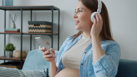 pregnant woman listening to music on smartphone