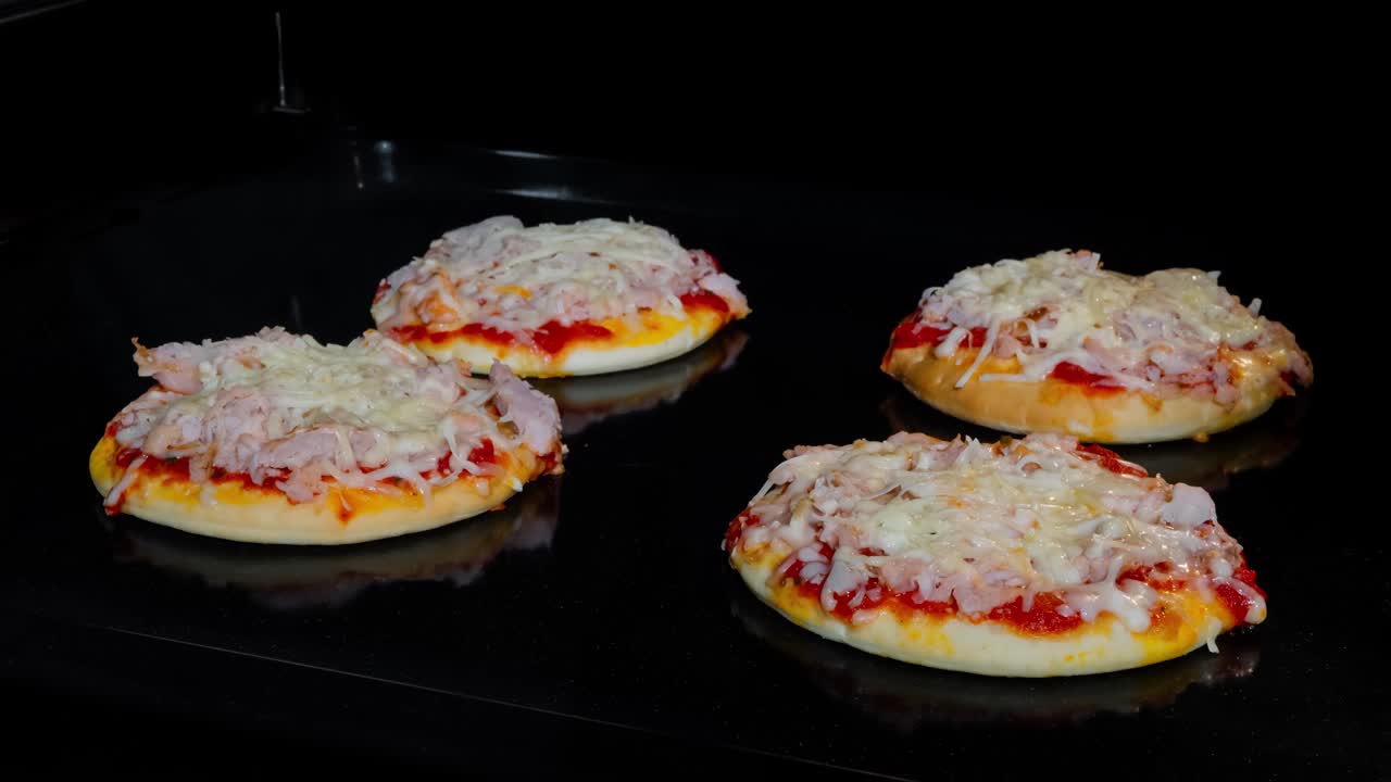 Timelapse - four homemade mini pizzas baking in electric oven at home