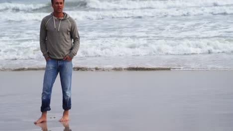 hombre maduro de pie en la playa
