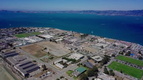4k aerial drone view of treasure island san francisco bay area surrounded by turquoise blue ocean sea water waves camera move forward inside