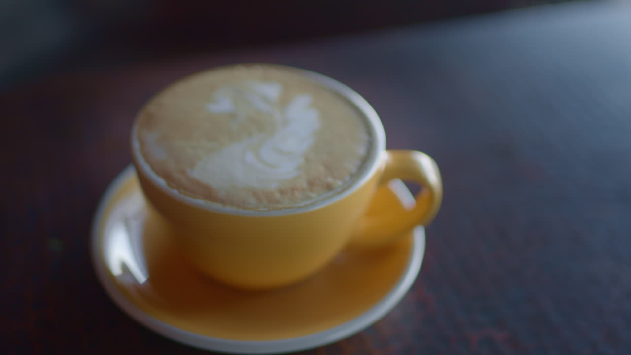 The coffee roasting process. A beautifully prepared cafe latte in a small organic coffee shop.