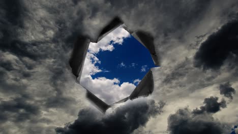 un agujero con bordes rasgados en el cielo lluvioso a través del cual puedes ver el cielo azul.