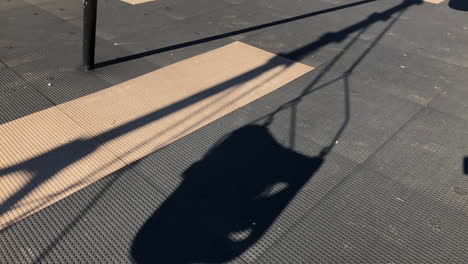 empty toddler swing set in park, winter time