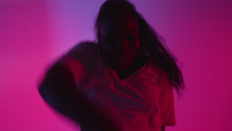 Full-Length-Studio-Shot-Of-Young-Woman-Dancing-Against-Blue-And-Pink-Lit-Background-3