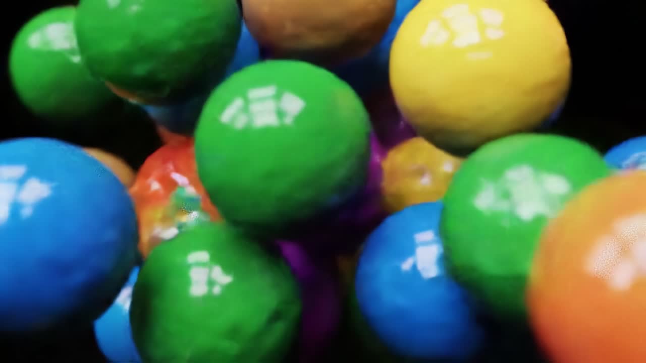 Brightly colored balls of various sizes roll and bounce together in a lively arrangement within an artistic studio. The colors create a joyful and playful atmosphere, energizing the space.