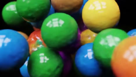 brightly colored balls of various sizes roll and bounce together in a lively arrangement within an artistic studio. the colors create a joyful and playful atmosphere, energizing the space.