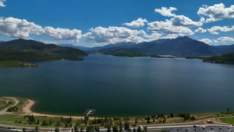 avión no tripulado cinematográfico breckenridge estación de esquí montaña ancho botes a motor navegando lago dillon anfiteatro colorado nueve millas rango verano cielo azul nubes de día frisco silverthorne presa hacia adelante movimiento
