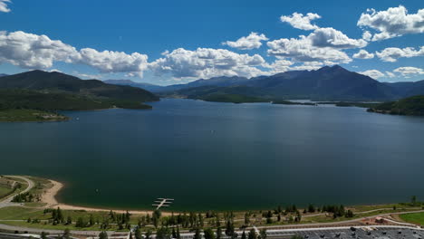 aerial cinematic drone breckenridge ski resort mountain wide motorboats sailing lake dillon amphitheater colorado 9 mile range summer blue sky clouds daytime frisco silverthorne dam forward motion