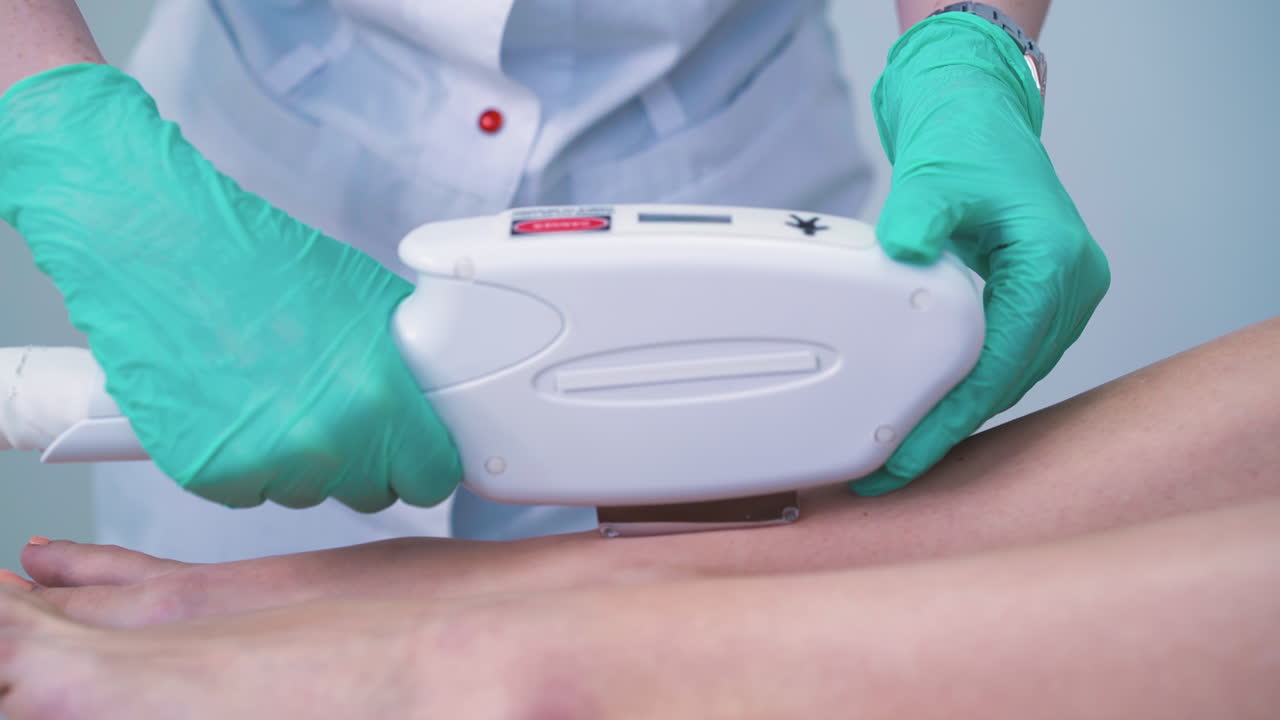 un cosmetologo di salone con i guanti fa l'epilazione laser a una ragazza