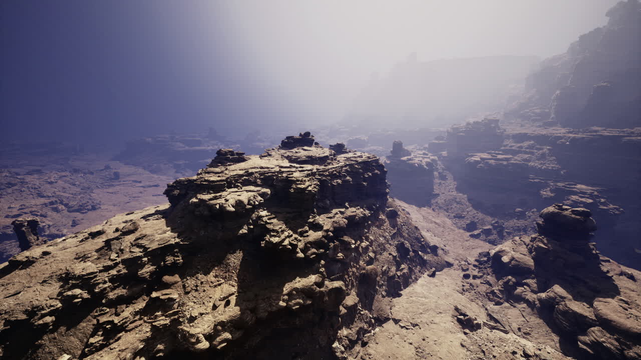 Mysterious rocky landscape shrouded in fog near a canyon at dawn