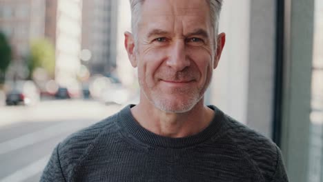 montage of a smiling mature man in casual clothes standing in a urban environment, looking directly at the camera and slightly changing his expression