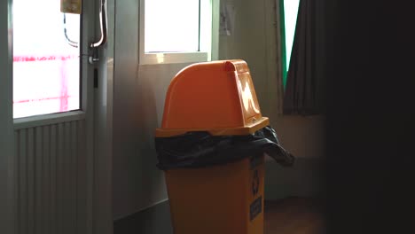 View-on-yellow-trash-garbage-bin-in-the-room-Waste-container-view-from-behind-seat