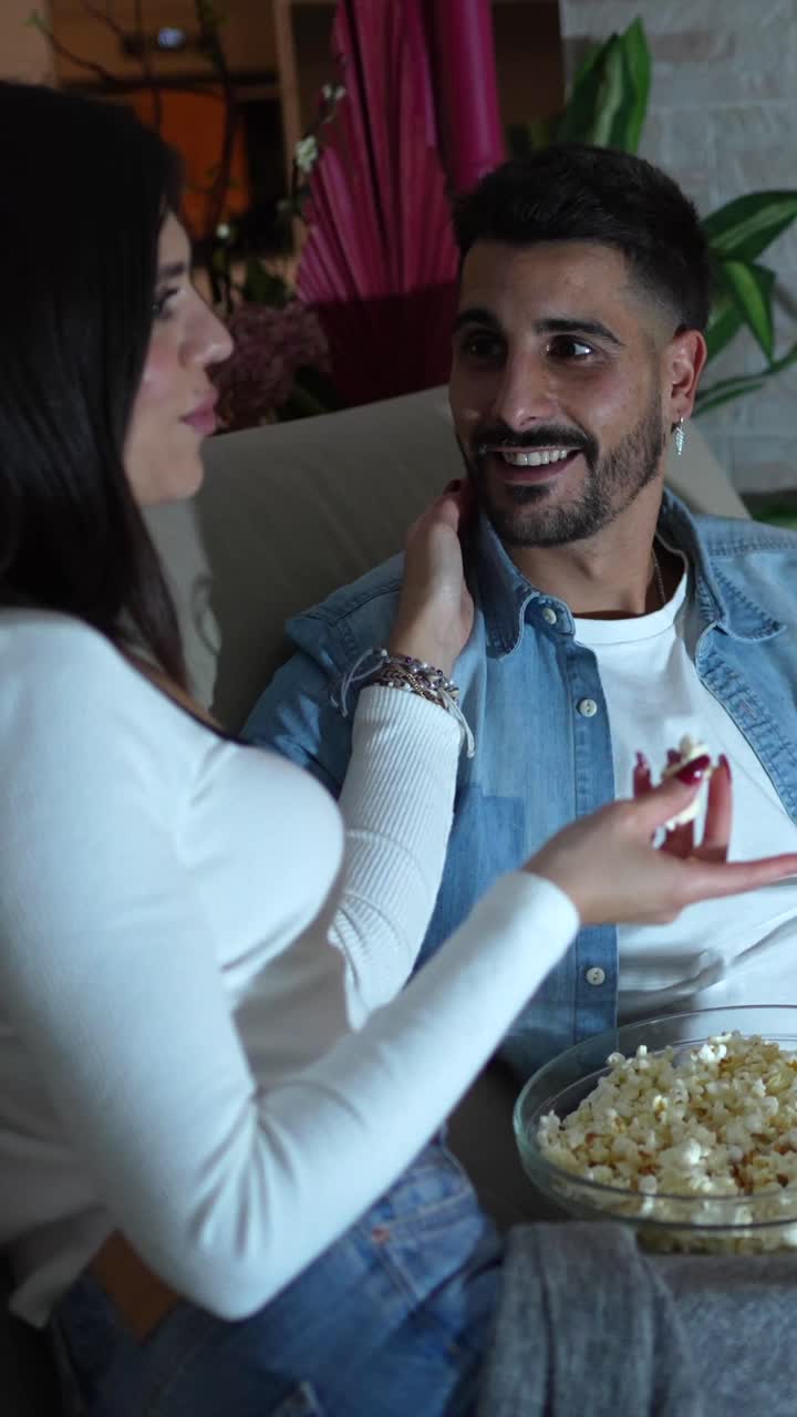 Homem assistindo à TV com pipoca
