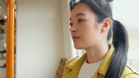 Close-Up-Of-Young-Woman-Sitting-On-Underground-Train-On-Journey-To-Work-Or-Visiting-City