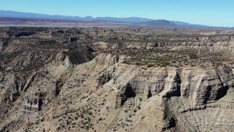 flyover: steep mesas of dry eroded sandstone on mountain plateau