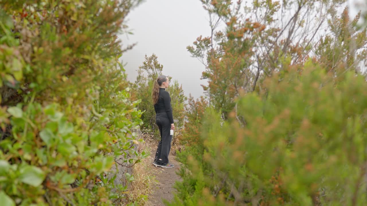 여자 하이커 는 손 에 카메라 를 들고 넓은 바다 의 멋진 전망 을 즐긴다