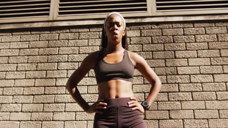 Portrait-of-african-american-woman-exercising-outdoors-looking-to-camera-and-breathing-deeply