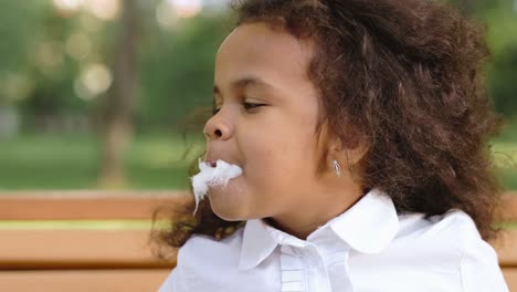 child eating cotton candy in a park